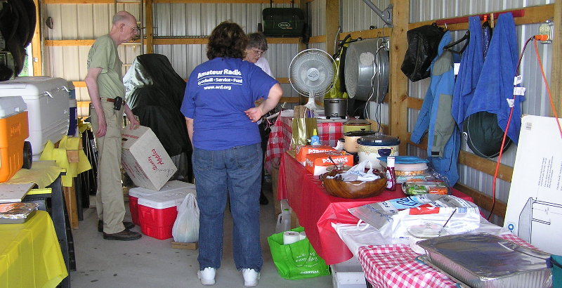 The Food Captain - Charlie Preston - K4LJH is assisted with arrangements for the Friday Night Dinner. Photograph by Denny Boehler - KF4TJI of Leesburg, Virginia.